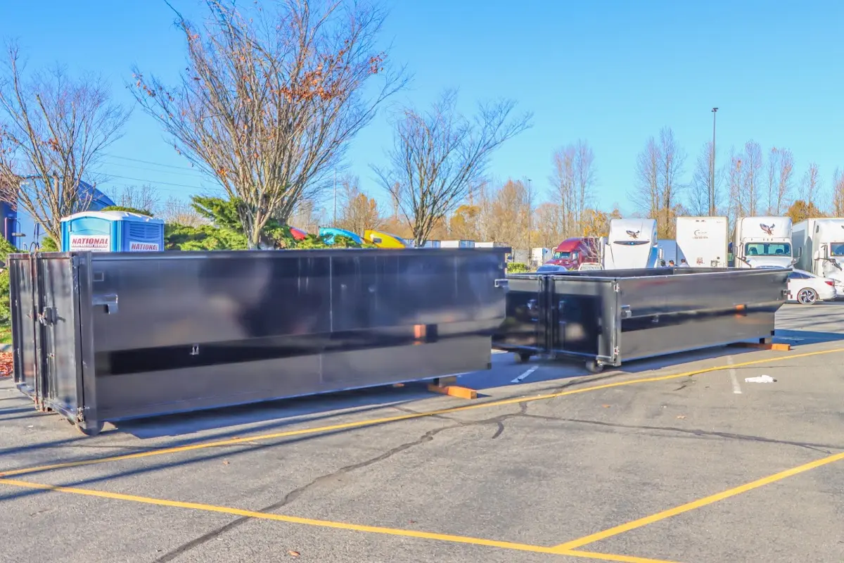 Professional dumpster rental service with roll-off container on residential driveway in Prattville